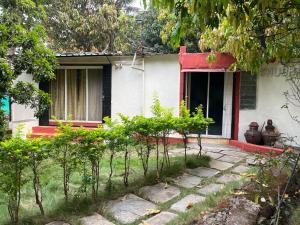 a small white house with a red trim at Private Farm Stay in Pune