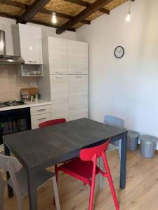 una cocina con mesa negra y sillas rojas en Appartamento da Patrizia, en Simaxis