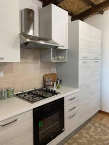 cocina con armarios blancos y fogones en Appartamento da Patrizia, en Simaxis