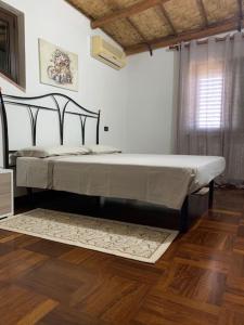 Cama grande en habitación con suelo de madera en Appartamento da Patrizia, en Simaxis