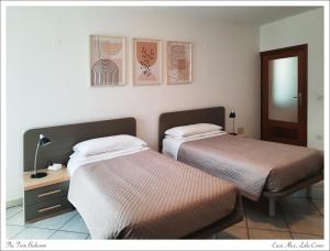 um quarto com 2 camas e uma mesa com um espelho em Azalea di Gigliola Ziello - "Casa Alice" em Cremia