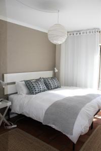 a bedroom with a large white bed and a lamp at 36 @ Plett! in Plettenberg Bay