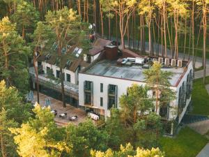 - une vue sur une maison blanche dans les bois dans l'établissement ESE HOTEL, à Birštonas