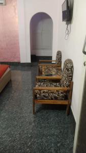 a room with two chairs and a bed in it at Hotel Swapna in Vānivilāsa Puram