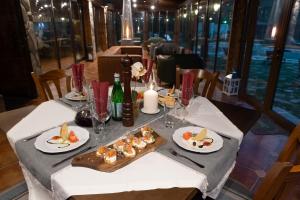 Guest House Valevtsi في Valevtsi: طاولة مع أطباق من الطعام وكؤوس النبيذ