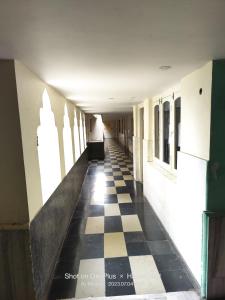 a hallway of a building with a checkered floor at Hotel Swapna in Vānivilāsa Puram