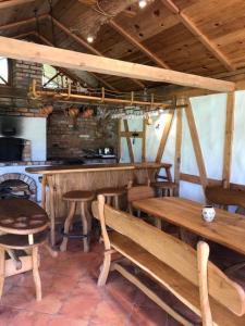 restauracja z drewnianymi stołami i krzesłami oraz blatem w obiekcie Pušų gaudyklė w mieście Ginučiai