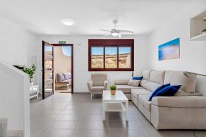 un soggiorno con un divano e un tavolo di MEDANO4YOU La Jaquita Terrace Holiday Home a El Médano