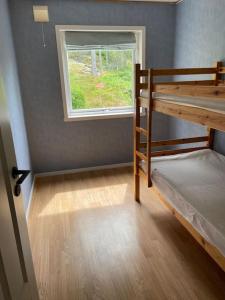 ハルデンにあるTrivelig nyoppusset hus ved femsjøen.の二段ベッド2台と窓が備わる客室です。