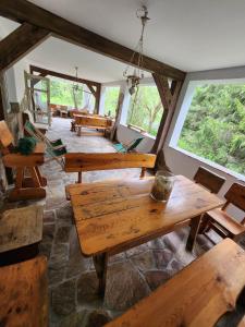 Cette grande chambre dispose de tables et de bancs en bois. dans l'établissement Włudzikówka, à Polana