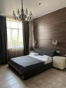 a bedroom with a bed and a chandelier at Borovik in Novosilki