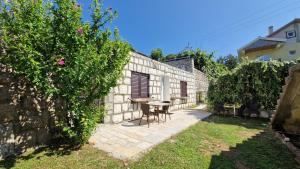 an external view of a stone house with a table and chairs at R&B Apartments in Budva +47 photos