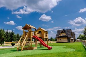 a playground with a slide in front of a house at Domki Baligówka Aurelia i Maximus in Zakopane