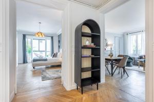 uma sala de estar com uma prateleira de livros pretos em Sweet Inn - Wagram em Paris