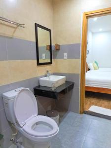 uma casa de banho com um WC, um lavatório e um espelho. em GREEN TOWN hotel HỘI AN em Hoi An