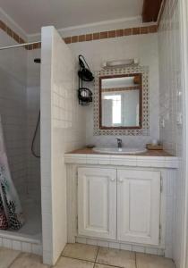La salle de bains est pourvue d'un lavabo blanc et d'un miroir. dans l'établissement Maison dans le domaine du golf, à Roquebrune-sur Argens