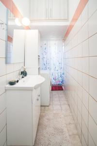Baño blanco con lavabo y espejo en Froso's Home, en Zarós