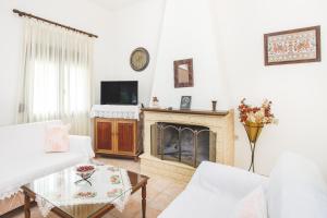 a living room with a fireplace and a tv at Froso's Home in Zaros