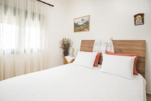 1 dormitorio con 2 camas blancas y ventana en Froso's Home, en Zarós