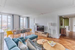 een woonkamer met een blauwe bank en een tafel bij Apartment Bastille by Studio prestige in Parijs