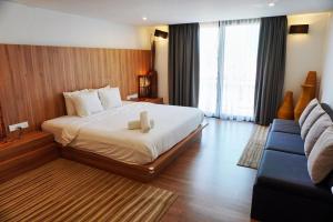 een hotelkamer met een bed en een bank bij Lot 33 Boutique Hotel in Pantai Cenang