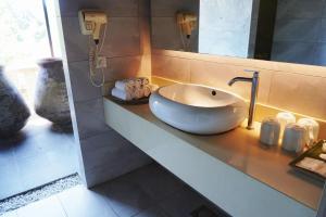 uma casa de banho com um lavatório e um espelho em Lot 33 Boutique Hotel em Pantai Cenang