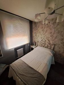 um quarto com uma cama, uma janela e uma cortina em En el Cielo de Salamanca em Salamanca