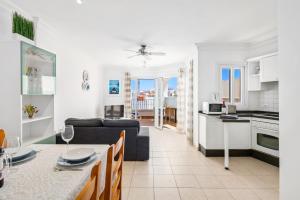 a kitchen and living room with a couch and a table at Bahia Blue - La Caleta in Adeje