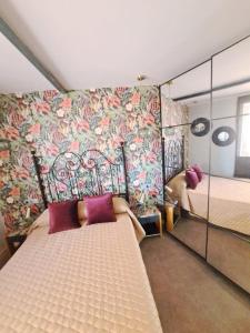 um quarto com duas camas e uma parede coberta de flores em En el Cielo de Salamanca em Salamanca