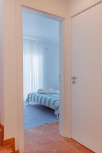 a door leading to a bedroom with a bed at Casa do Terreiro in Tavira