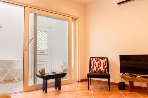 a living room with a sliding glass door and a chair at Casa do Terreiro in Tavira