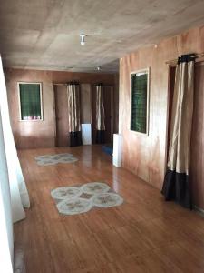 a large room with a wooden floor and a room with windows at Ady ching's Place 