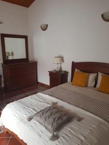 een slaapkamer met een groot bed en een spiegel bij Cosy apartment at Portuguese Quinta in Casal Diz