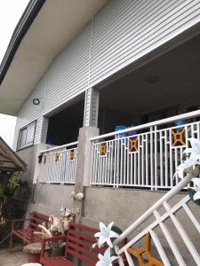 una casa con balcón y 2 bancos en el porche en Ady ching's Place 