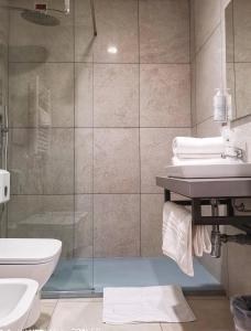 a bathroom with a shower and a toilet and a sink at Hotel Central Station in Milan