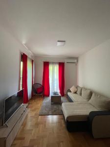 - un salon avec un canapé et des rideaux rouges dans l'établissement Marina, à Budva