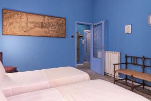 a room with two beds and a blue wall at Un tocco di Blu - La Vegra Apartment in Ferrara
