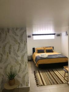 Un dormitorio con una cama y una pared con plantas. en Cantinho da Susana, en Coímbra