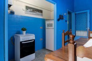 a blue kitchen with a stove and a table at Un tocco di Blu - La Vegra Apartment in Ferrara