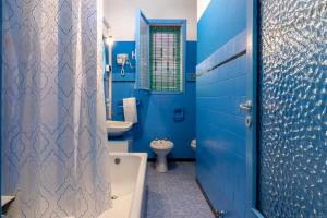 Baño azul con bañera y lavamanos en Un tocco di Blu - La Vegra Apartment en Ferrara