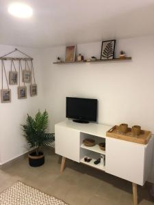 ein Wohnzimmer mit einem TV auf einem weißen Schrank in der Unterkunft Cantinho da Susana in Coimbra