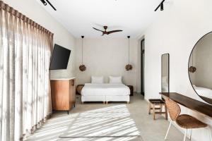 a bedroom with a white bed and a mirror at Hotel Anilevich Mansion in Beer Sheva