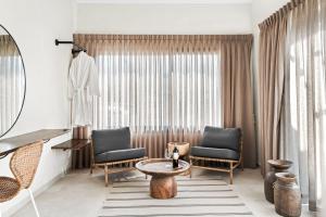 a living room with two chairs and a table at Hotel Anilevich Mansion in Beer Sheva