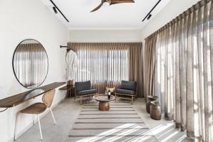 a room with two chairs and a table and a mirror at Hotel Anilevich Mansion in Beer Sheva