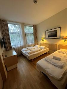 um quarto de hotel com duas camas e uma televisão de ecrã plano em Mitt hotell & apartments em Moss