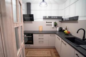 a kitchen with white cabinets and a black counter top at Apartman Niko in Livno