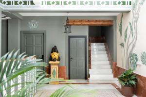 a hallway with two doors and stairs with plants at PUERTA DE ARMAS APARTMENTS in Seville