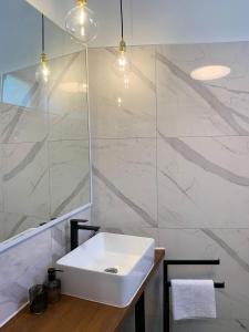 ein Badezimmer mit einem weißen Waschbecken und einer Dusche in der Unterkunft Perla Alba Apartments in Tribunj