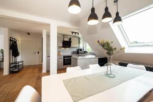 a kitchen and dining room with a white table and chairs at Luxury Apartment on the Rhein in Busingen am Hochrhein
