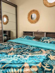 Dormitorio con cama con edredón azul y espejo en Villa cap zen and spa, en Petite Île
